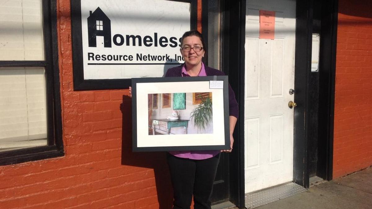 Elizabeth Dillard, executive director of the Homeless Resource Network, holds a photo taken by Columbus artist Rob St. Clair that will be part of a silent auction at an annual Wine Tasting Mingle fundraiser that will be held 6 to 8 p.m. Friday at The Loft, 1032 Broadway. Proceeds will benefit the network.