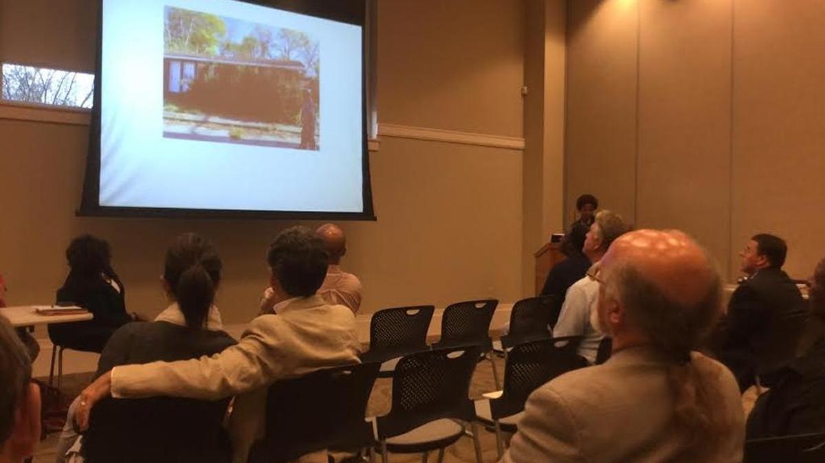 Residents attending a forum at Columbus Public Library Thursday night saw overgrown brush almost covering a house. City officials were on hand to offer solutions.