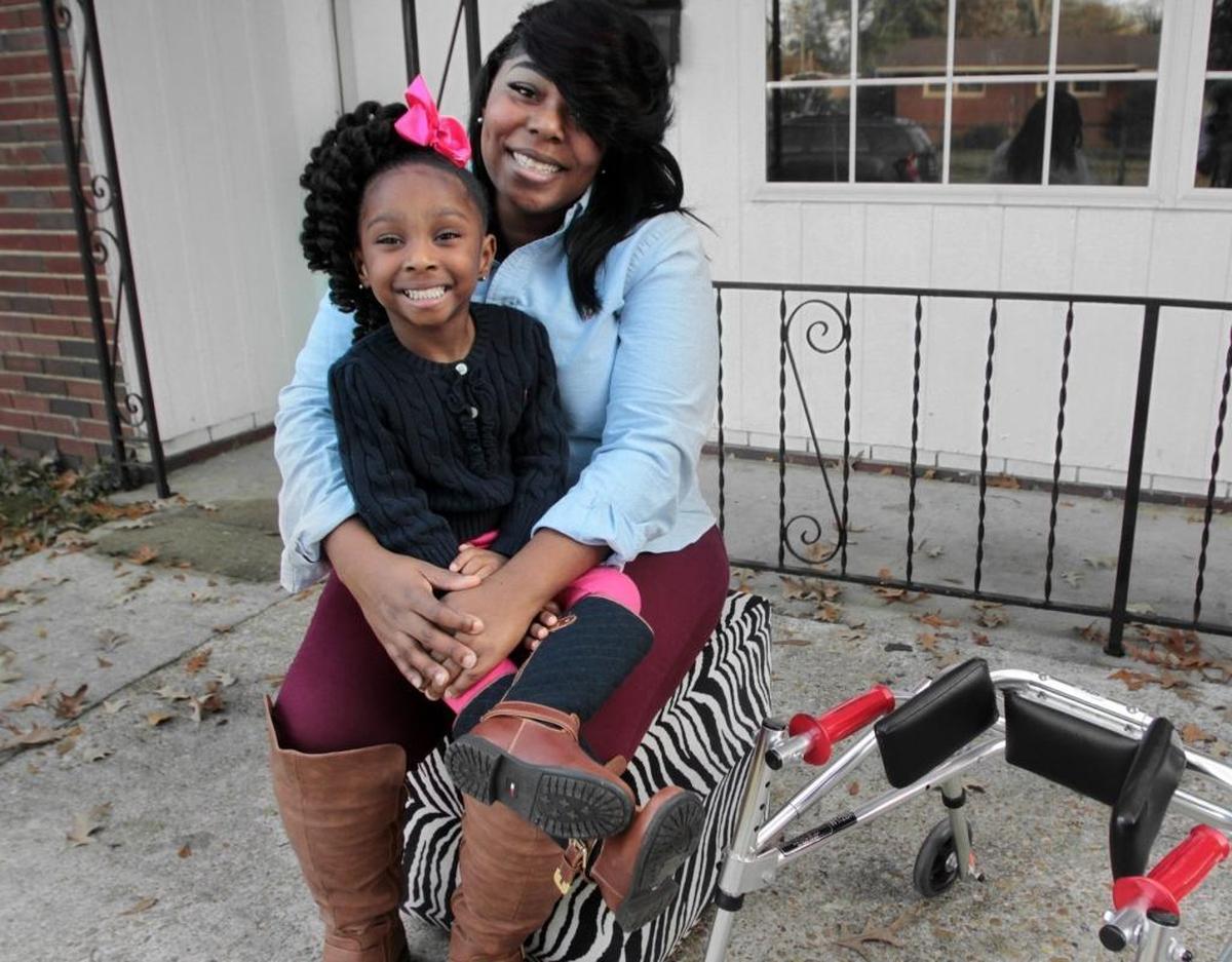Four-year old Genasis Davis sits with her mother Tyrisha Toney. The youngster’s foot was partially amputated, but according to her mother, she doesn’t let anything stop her.
