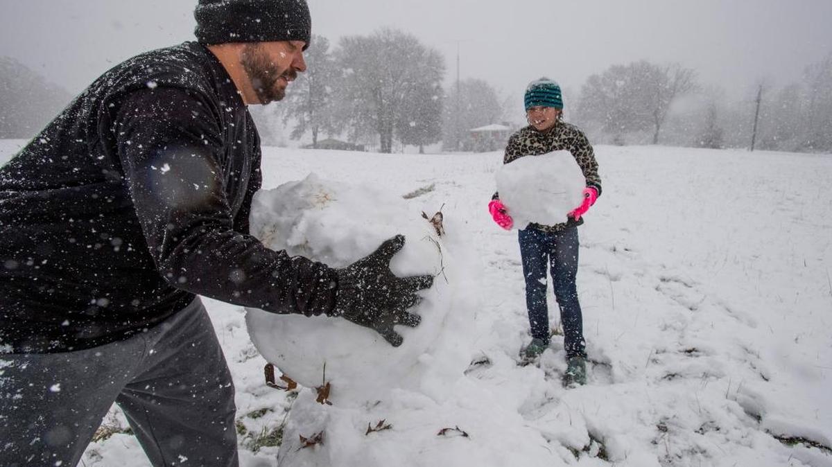 Stephen Fanning and his daughter Addison Fanning build a snowman during the heavy snow fall in Clanton, Ala. on Friday, Dec. 8, 2017.