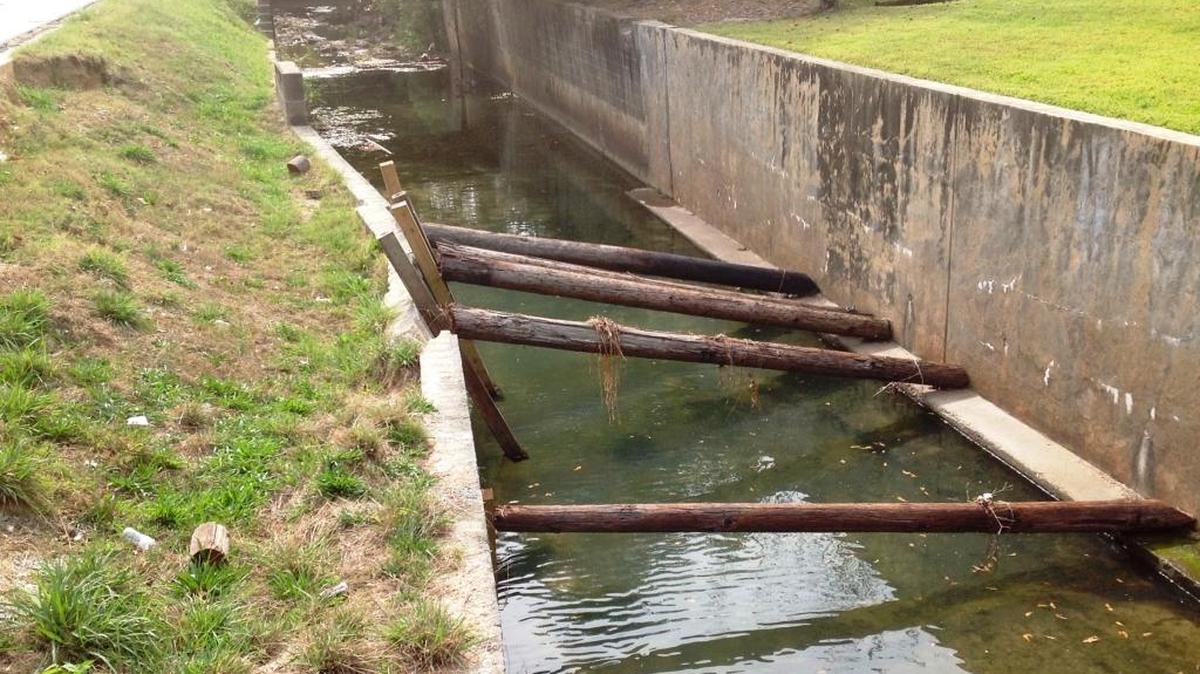 Utility poles are braced between the east and west retaining walls to prevent further collapse into Weracoba Creek.