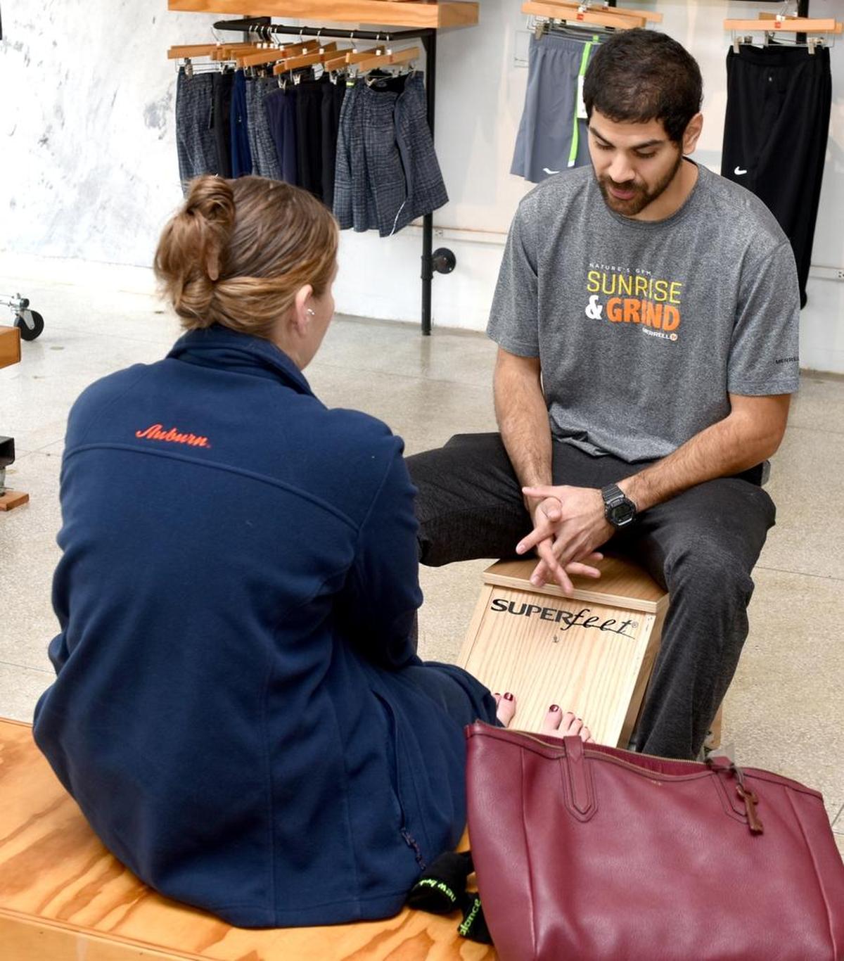 Big Dog Running Company’s Carlos Salgato working with customer to selecting running shoe during the Small Business Saturday, November 25, 2017