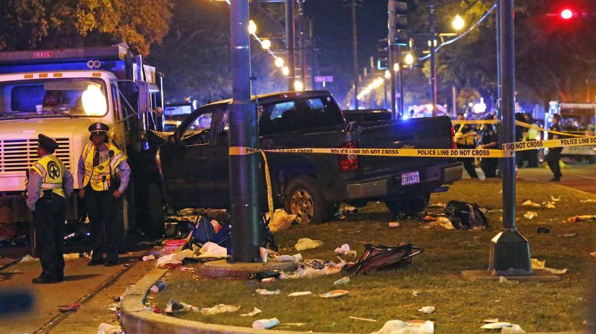 Police stand next to a pickup truck that slammed into a crowd in New Orleans, causing multiple injuries.
