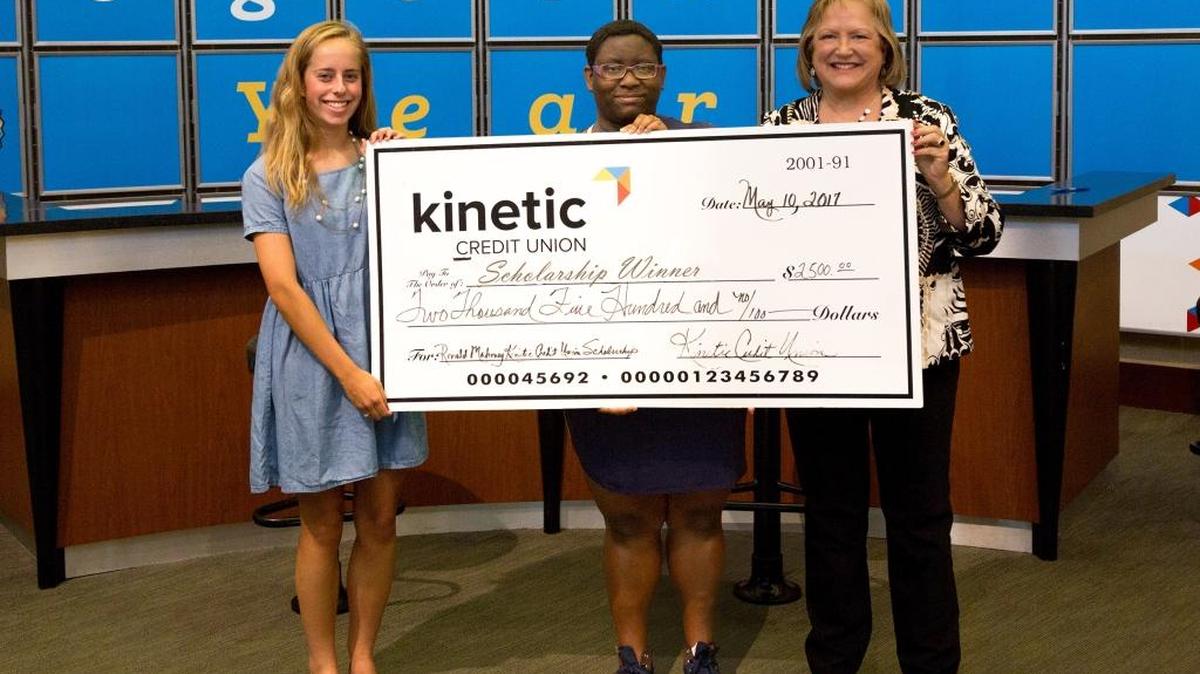 Receiving $2,500 each as the 2017 winners of the Ronald J. Mahoney Kinetic Scholarships are, from left, Madison Wood of Columbus High School and Unique Henry of Carver High School, posing with Kinetic Credit Union president and chief executive officer Janet Davis.