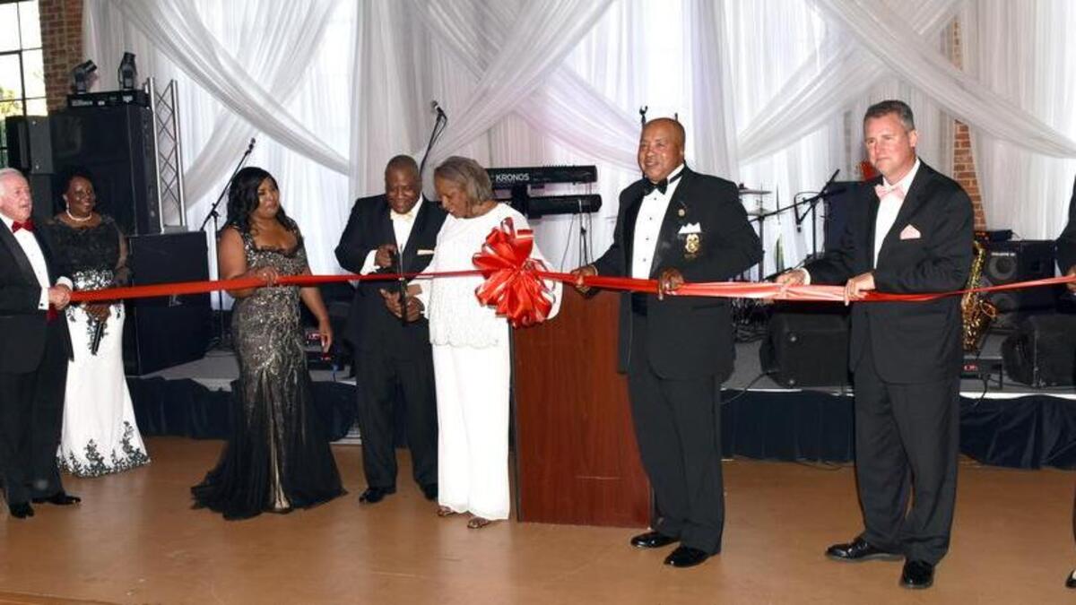 Columbus Mayor Pro-Tem Evelyn Turner-Pugh and Phenix City Mayor Eddie Lowe with assistance from other Phenix City officials cutting the ribbon on the one night only honorary deed to the River Mill Event Center for his annual scholarship ball Saturday June 10, 2017