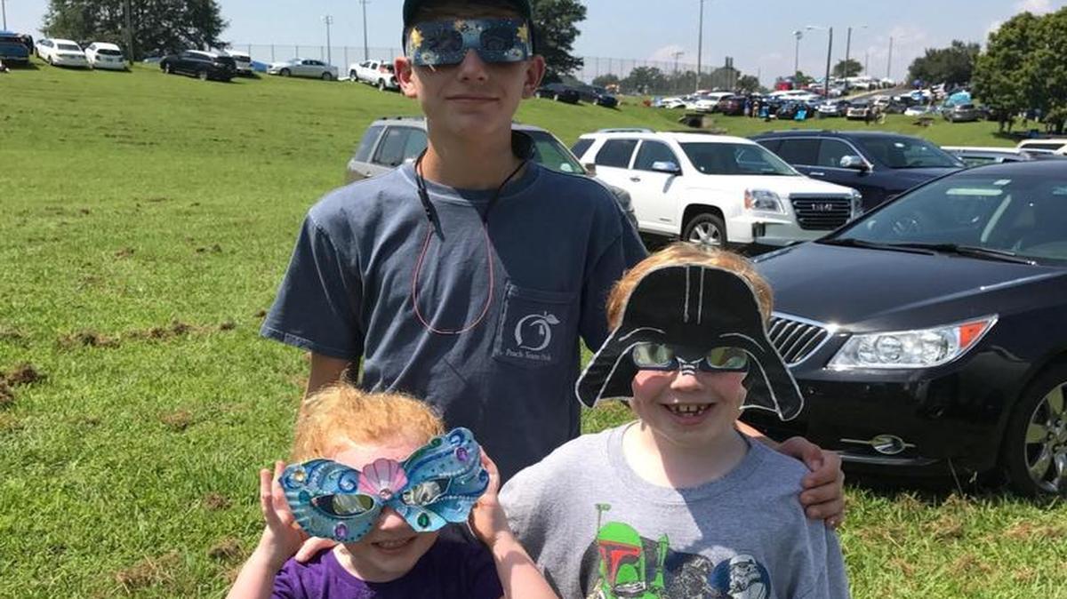 Laura Solomons’ nephew, Ryan Smith, a Blackmon Road Middle School student, and her two small children, Platt and Katie, both St. Luke School students, pose with their masks on Monday in Athens, Tenn., shortly before checking out the “Great American Eclipse.” Solomons, a Columbus High teacher, and her husband, Ken, traveled to an area which featured a 100-percent elipse of the sun by the moon as seen from Earth. With them were Columbus High teacher Amanda Hefner and her family. --