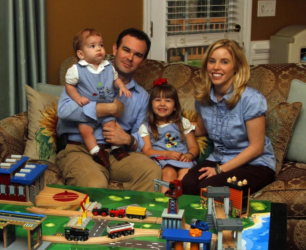 In this 2014 photo, Chris and Melissa Johnson sit inside their living room with adopted children Joshua, 1, and Sarah Ruth, 3. Joshua died of cancer on Christmas Day, 2014.