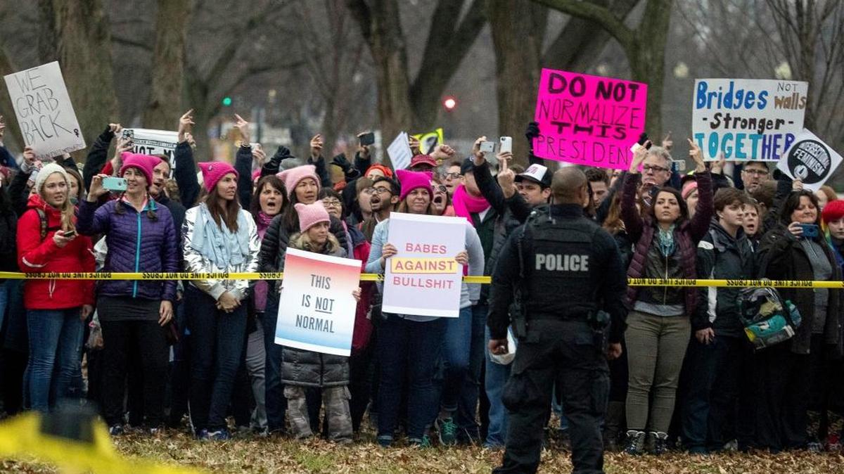 People with the Women's March on Washington at the Ellipse of the White House can be seen from a motorcade carrying President Donald Trump as he arrives at the White House, in Washington, Saturday, Jan. 21, 2017.
