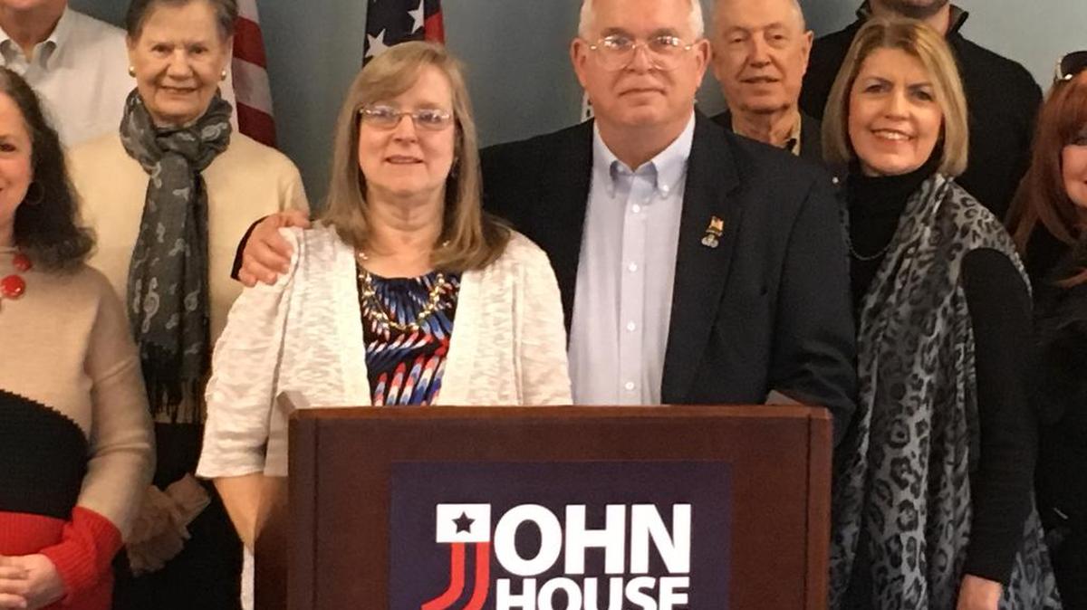Retired Army Col. John House, center right, has his arm around his wife, Marilyn, as he poses with supporters Wednesday afternoon.