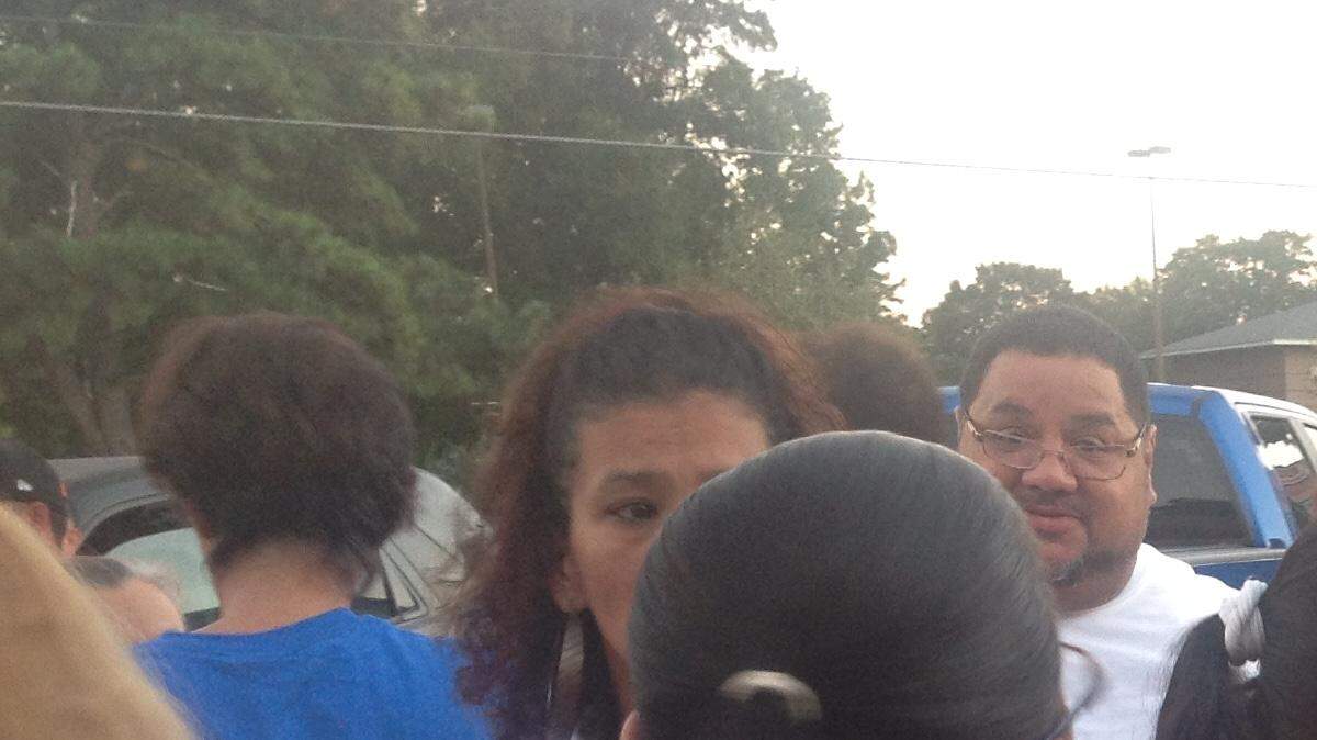 Mourners comfort "Lefty" Encarnacion's widow, Millie, at a candlelight vigil held in his memory. Encarnacion served as a community organizer in the Hispanic community for more than 20 years.