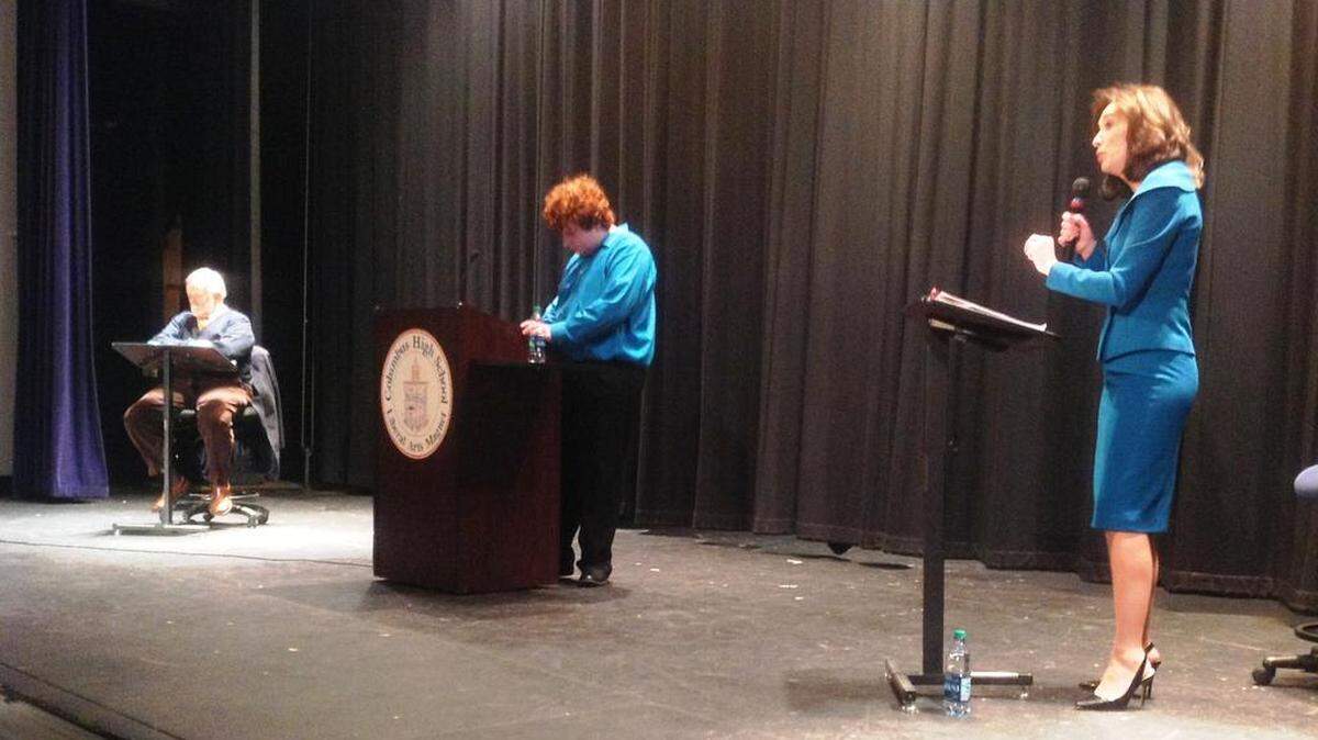 Mayor Teresa Tomlinson answers a question from moderator David Smith as former state Sen. Seth Harp, seated because of knee surgery, listens Wednesday night at Columbus High School.