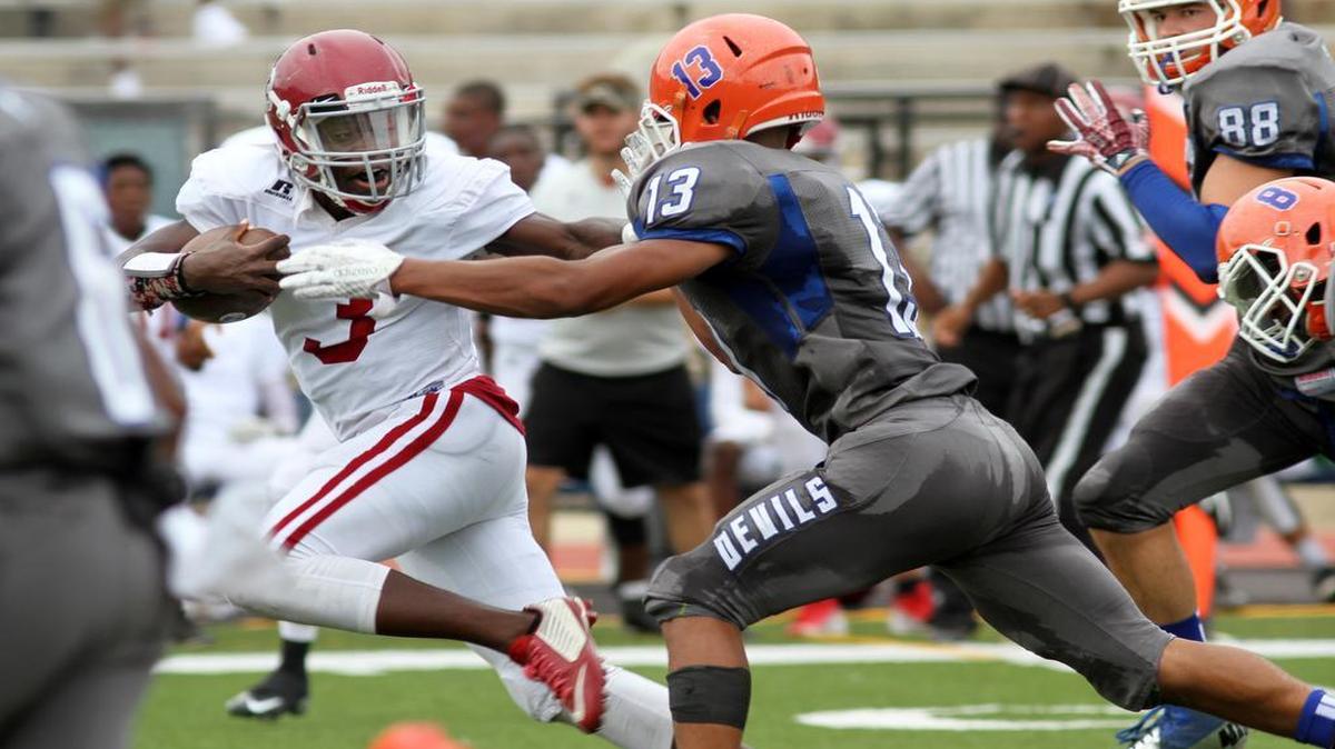 Jordan High's Emmanuel Mann stiff arms Jordan High's Anthony Bonner on his way to a 61-yard touchdown run during the Muscogee County School District Fall Classic at Kinnett Stadium Saturday. The Blue Devils beat the Red Jackets 47-32.