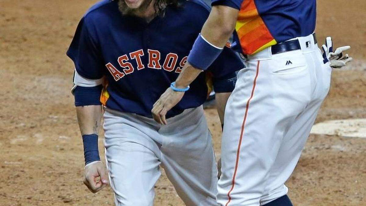 Houston Astros Colby Rasmus, left, and Carlos Correa celebrate Rasmus' two-run homer against the Boston Red Sox to tie up the game in the ninth inning of a baseball game Sunday, April 24, 2016, in Houston.
