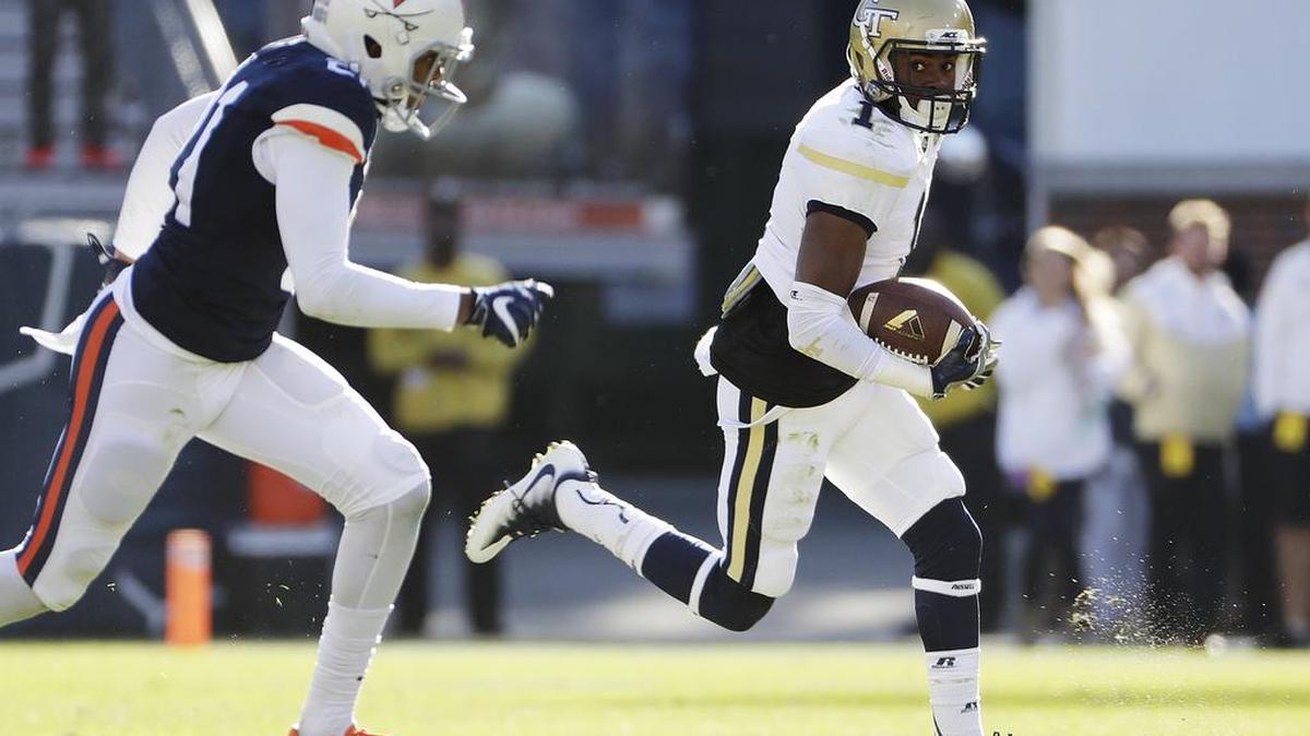 Georgia Tech’s Qua Searcy, right, runs the ball against Virginia’s Juan Thornhill, left, to score a touchdown in the third quarter in Atlanta on Saturday. Tech won 31-17.