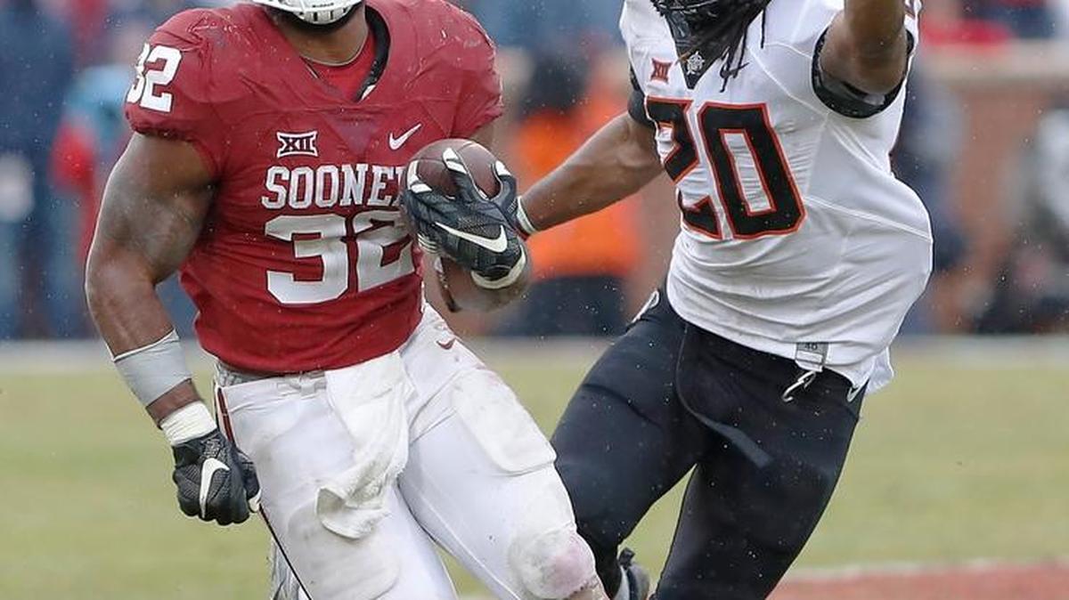 Oklahoma running back Samaje Perine (32) runs ahead of Oklahoma State linebacker Jordan Burton (20) during the second half of their Dec. 3 game in Norman, Okla.