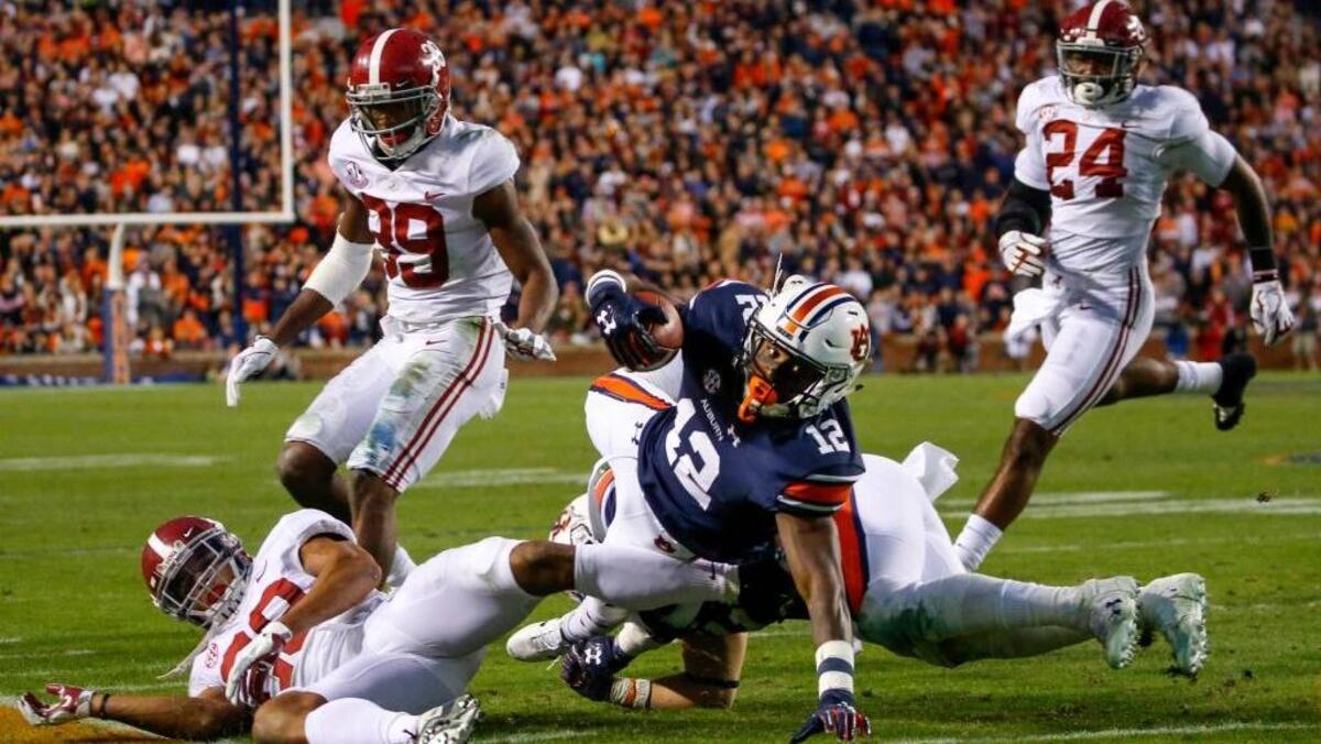 Auburn wide receiver Eli Stove (12) dives for extra yardage over Alabama defensive back Minkah Fitzpatrick (29) during the second half of the Iron Bowl NCAA college football game, Saturday, Nov. 25, 2017, in Auburn, Ala. 