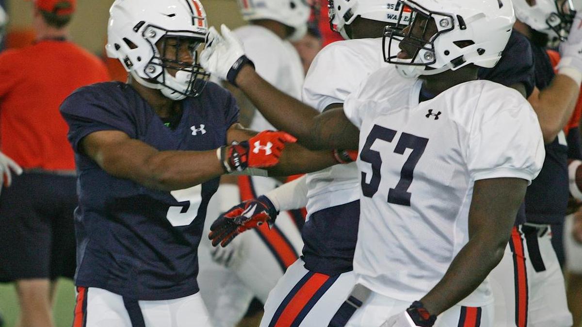 Auburn linebacker Deshaun Davis, No. 57, taps running back Kam Martin on the helmet at practice Sunday, Aug. 7, 2016 at the university's athletic complex.