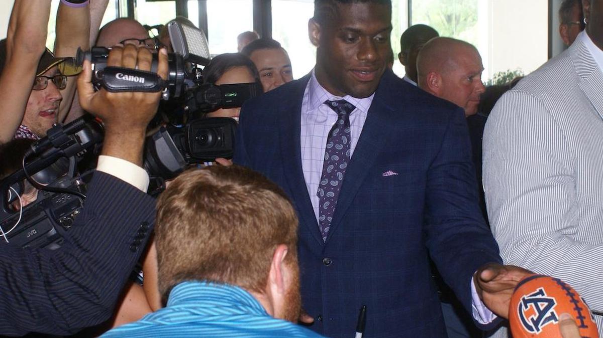 Auburn defensive lineman Carl Lawson signs autographs for fans in the Wynfrey Hotel lobby at SEC Media Days on Monday, July 11, 2016.