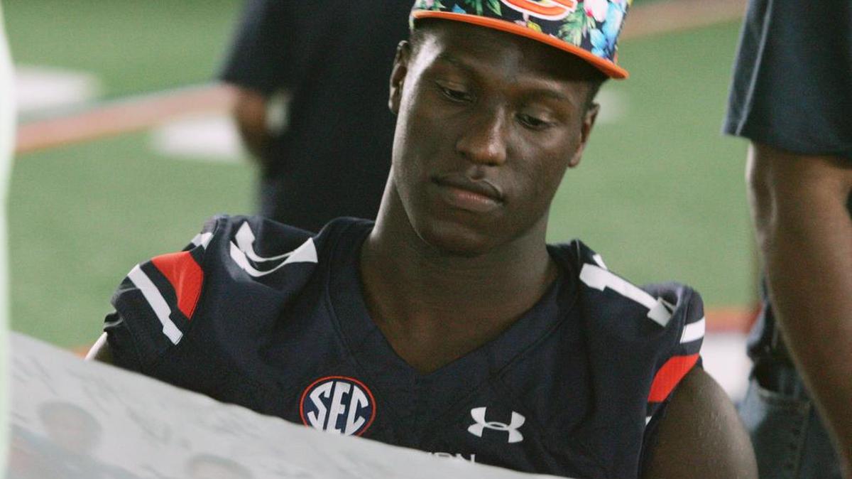Auburn wide receiver Marquis McClain looks at a signed poster during the program's annual fan day in August 2016.