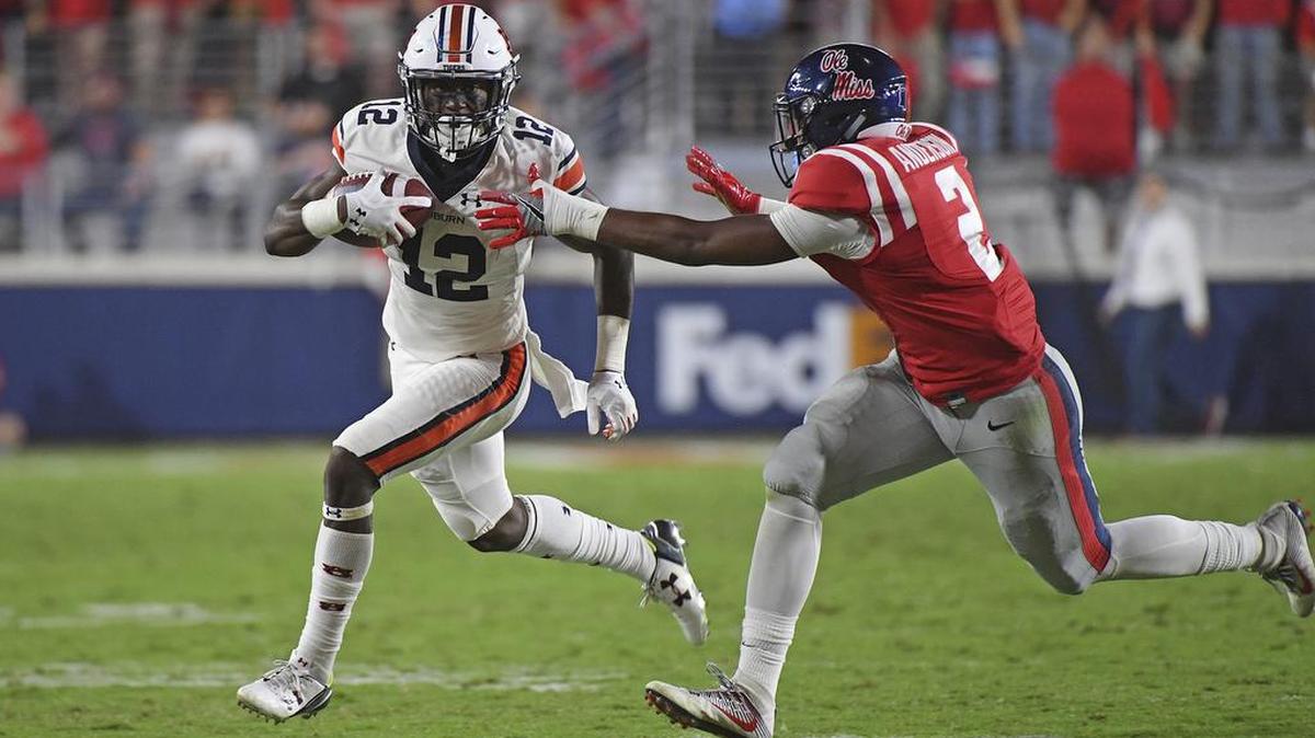 Auburn wide receiver Eli Stove, No. 12, looks for room past Mississippi defensive back Deontay Anderson in Oxford, Miss., Saturday, Oct. 29, 2016.