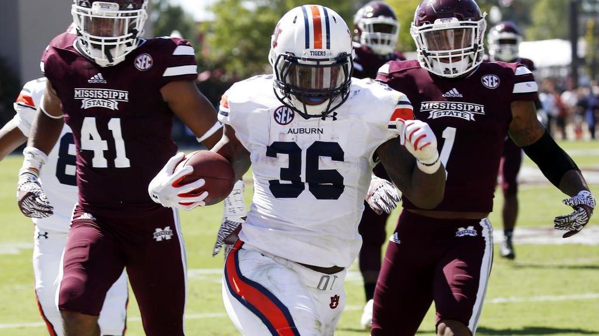 Auburn running back Kamryn Pettway (36) runs past Mississippi State defenders Saturday.