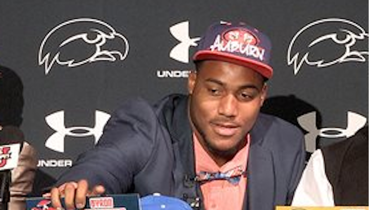 Armwood defensive end Byron Cowart, center, dons an Auburn hat after declaring that he would sign with the Tigers during a ceremony, Wednesday, Feb. 4, 2015, at Armwood High School in Seffner, Fla. Also pictured are Alcorn State commitment Noah Johnson, left, and Vanderbilt commitment Jordan Griffin.