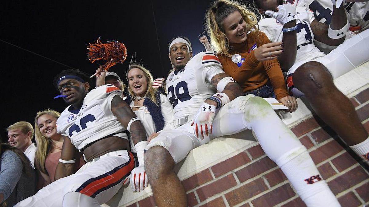 Auburn players celebrate with fans after an NCAA college football game against Mississippi in Oxford, Miss., Saturday, Oct. 29, 2016. No. 15 Auburn won 40-29.