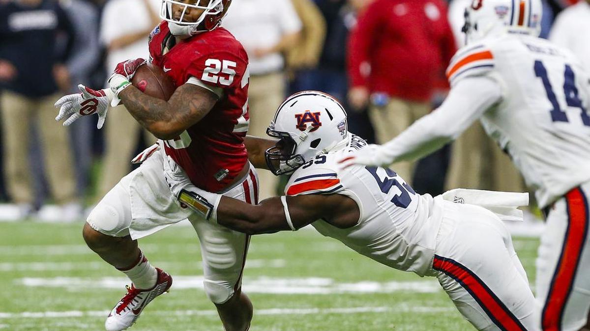 Oklahoma running back Joe Mixon, No. 25, tries to get around Auburn defensive lineman Carl Lawson, No. 55, as he carries the ball during the second half of the Sugar Bowl Monday, Jan. 2, in New Orleans.