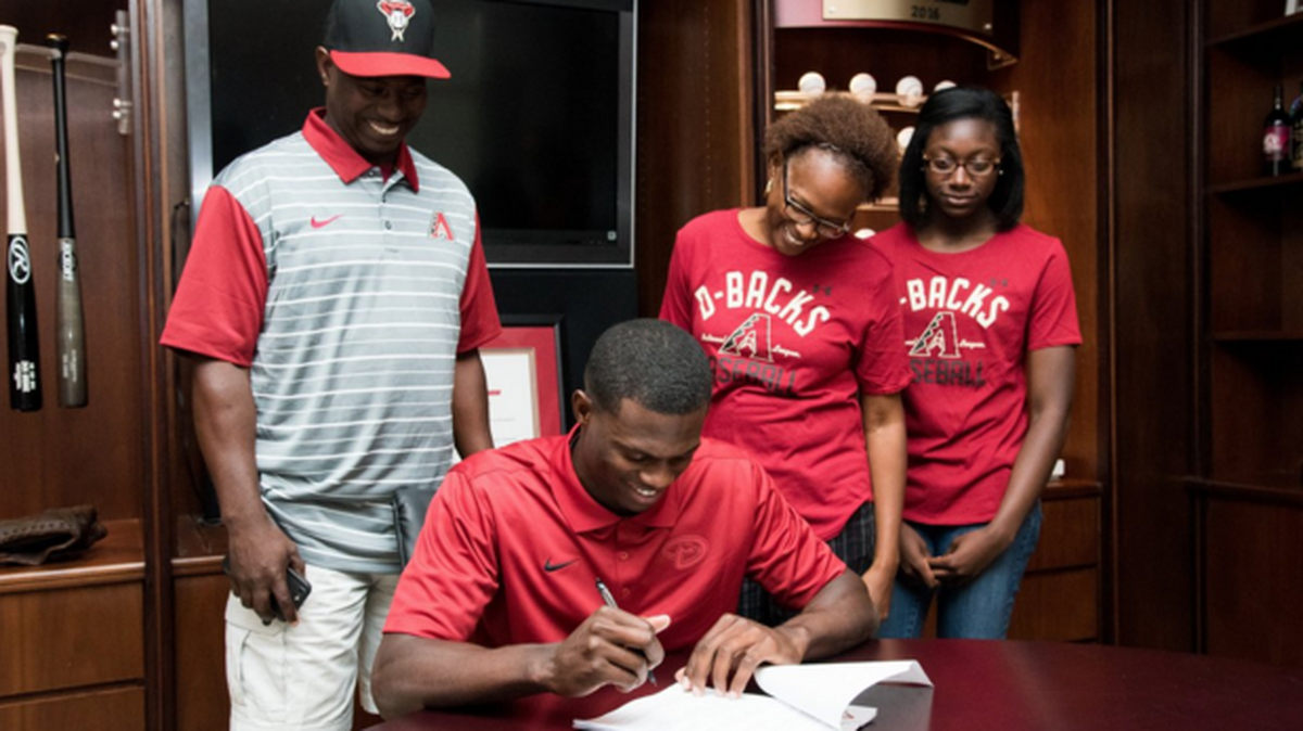 Former Auburn outfielder Anfernee Grier signs a contract with the Arizona Diamondbacks Wednesday at Chase Field.
