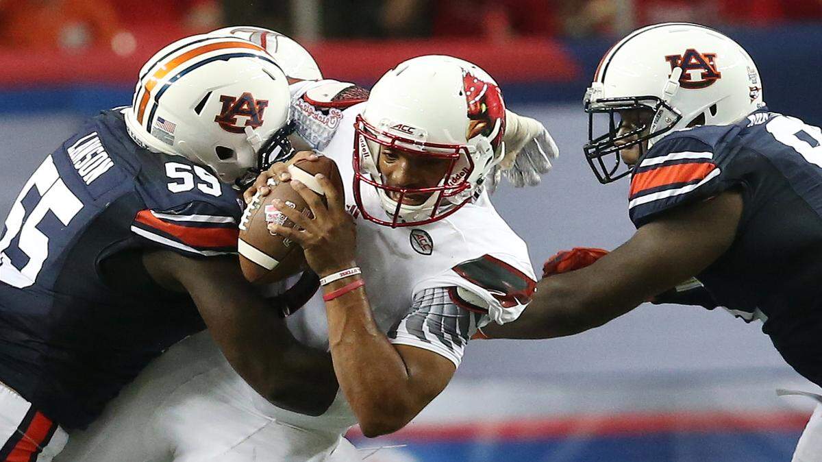 Auburn defensive lineman Carl Lawson (55) tackles Louisville quarterback Reggie Bonnafon (7) during the first half of an NCAA college football game, Saturday, Sept. 5, 2015, in Atlanta. (AP Photo/John Bazemore)