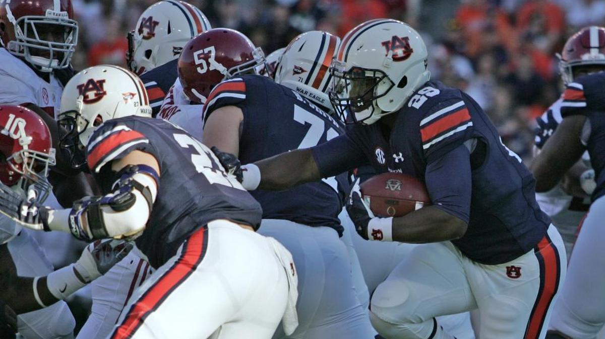Auburn running back Jovon Robinson, No. 29, carries the ball behind one of his offensive lineman last year against Alabama.