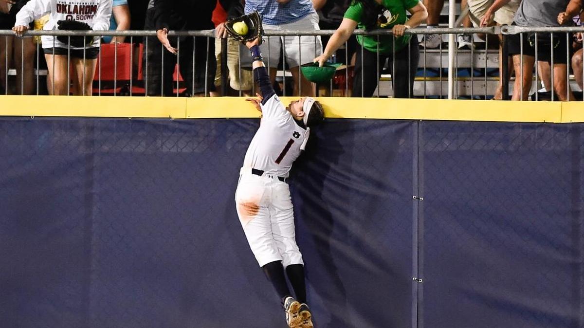 Tiffany Howard goes up to steal a home run away from Oklahoma’s Shay Knighten during Tuesday night’s Women’s College World Series game.