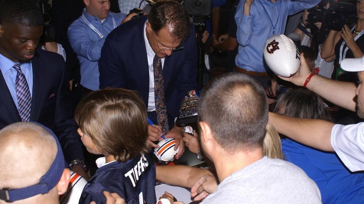 Auburn coach Gus Malzahn signs autographs at SEC Media Days on Monday, July 11, 2016.