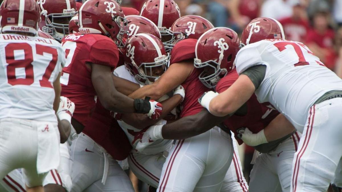 Alabama running back Damien Harris gets wrapped up by Rashaan Evans (32), Keaton Anderson (31) and others during the first half Saturday.