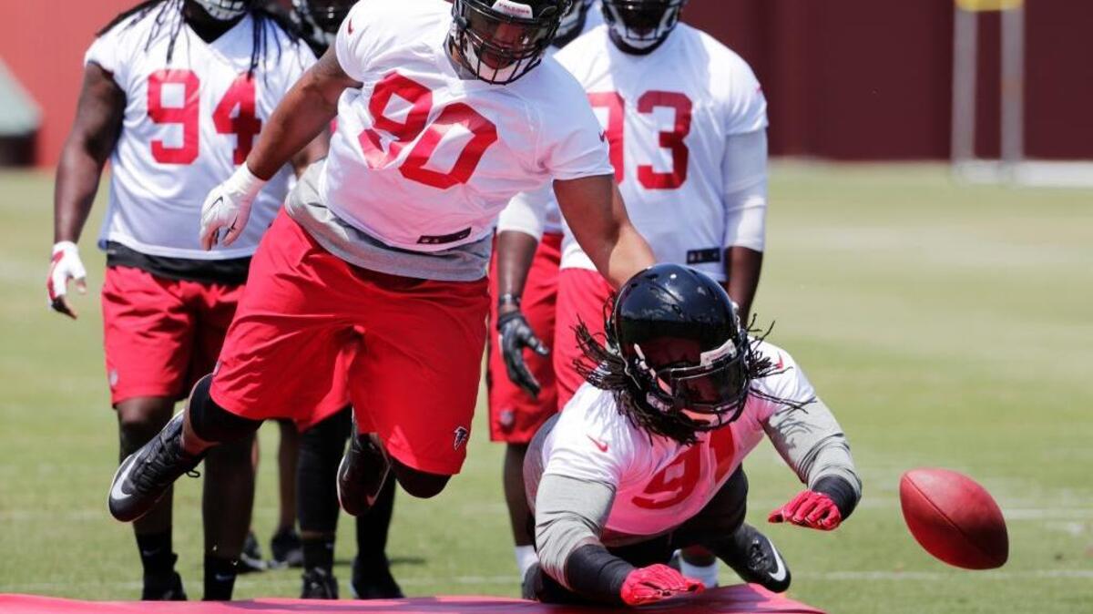 Atlanta’s Derrick Shelby, left, and Courtney Upshaw go through a drill at an NFL football practice Monday.
