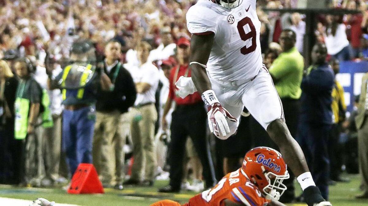 Alabama running back Bo Scarbrough (9) runs over a Florida defender during the Southeastern Conference championship NCAA college football game, Saturday, Dec. 3, 2016, in Atlanta.