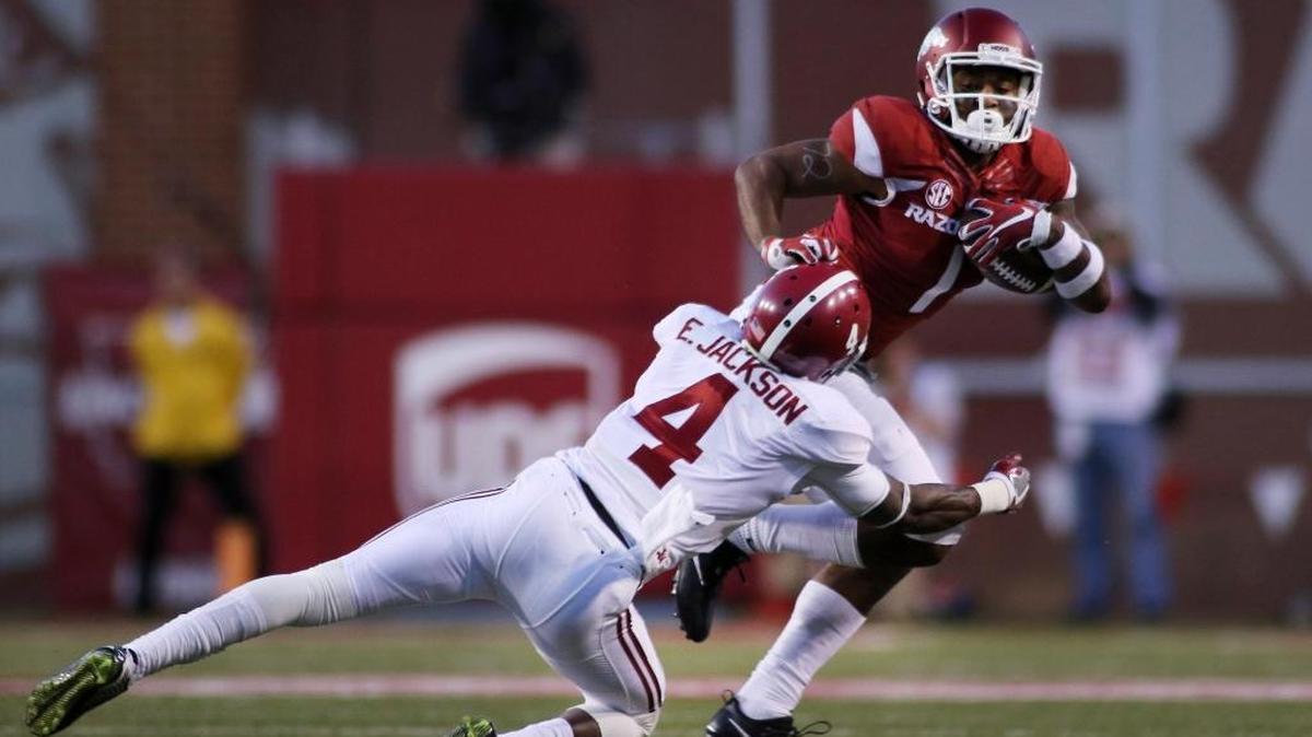 Arkansas’ Jared Cornelius attempts to dodge a tackle from Alabama’s Eddie Jackson during the first quarter of a game on Oct. 8.