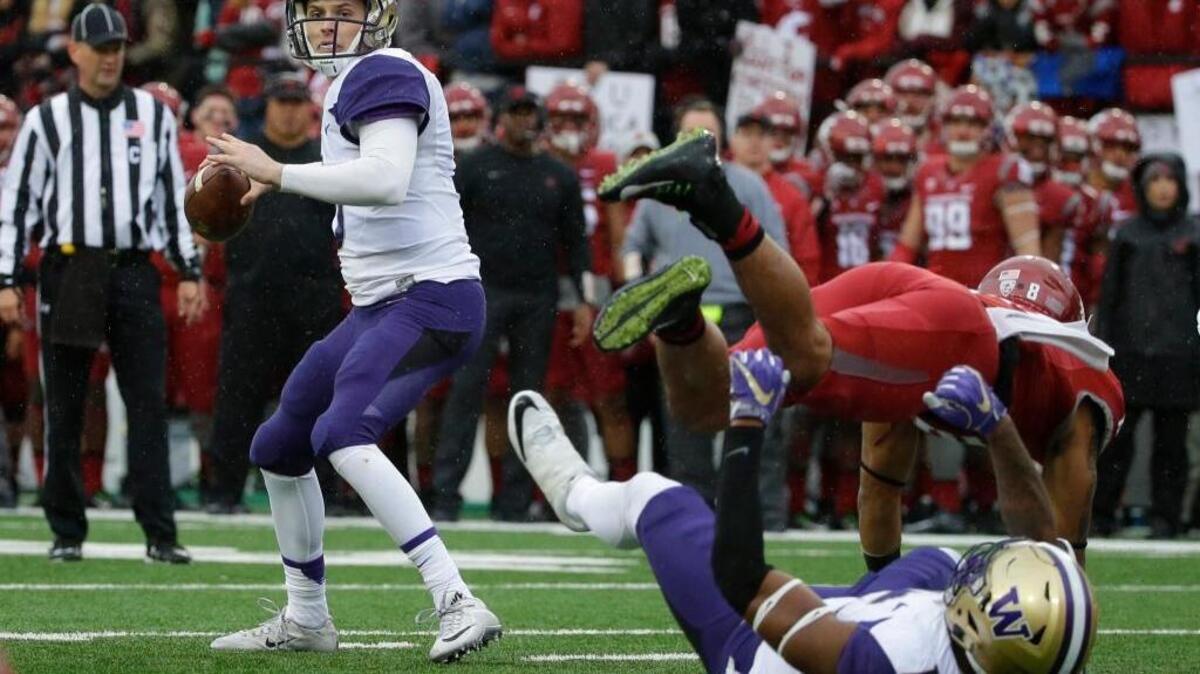 In this Nov. 25 file photo, Washington quarterback Jake Browning passes as Washington State safety Shalom Luani is blocked by Washington tight end Darrell Daniels in Pullman, Wash.