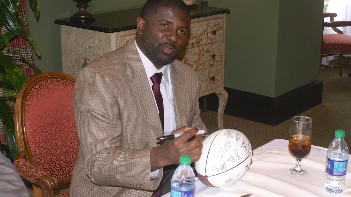 New Alabama secondary coach Derrick Ansley signs a football at the Chattahoochee Valley Bama Club spring dinner at the Green Island Country Club in Columbus.