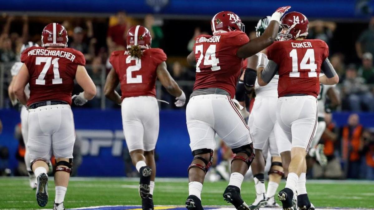 Alabama offensive lineman Cam Robinson (74) and quarterback Jake Coker (14) celebrate against Michigan State during the first half of the Cotton Bowl last December.