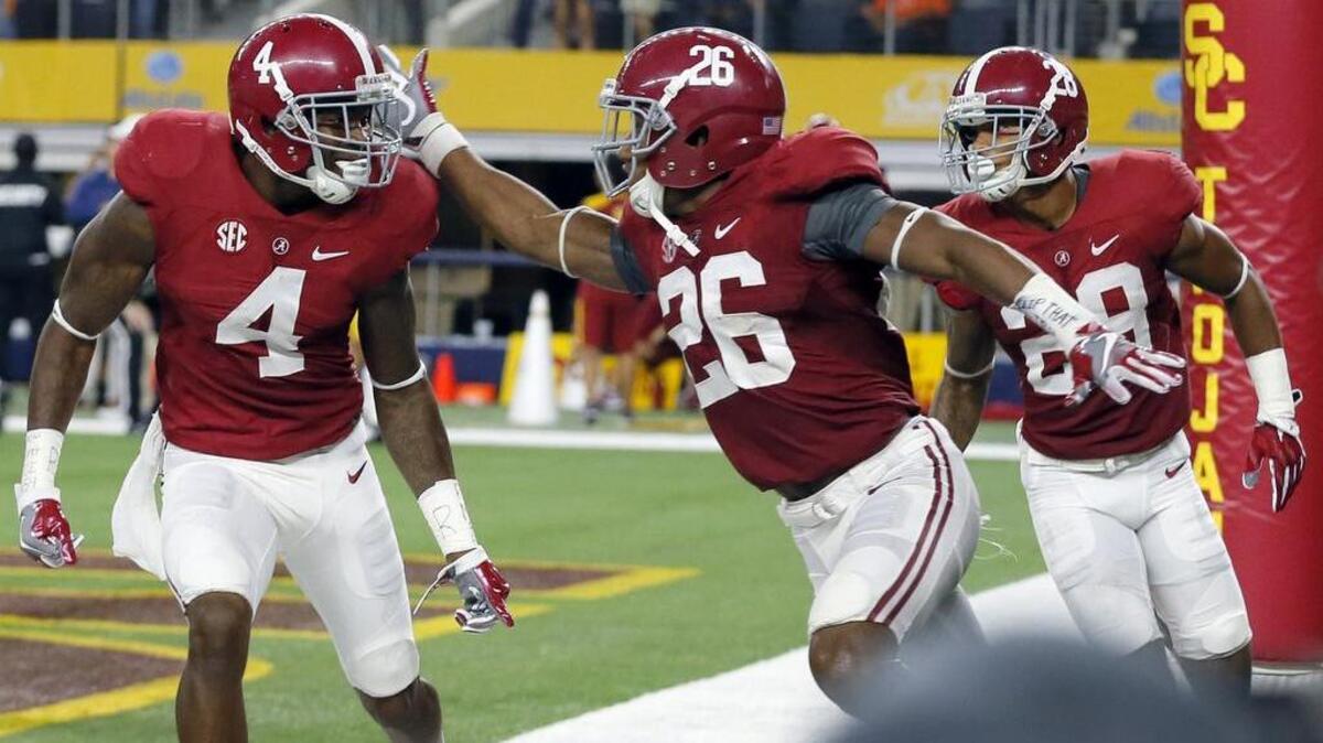 Marlon Humphrey of Alabama, left, is congratulated by teammates following his interception return for a touchdown.