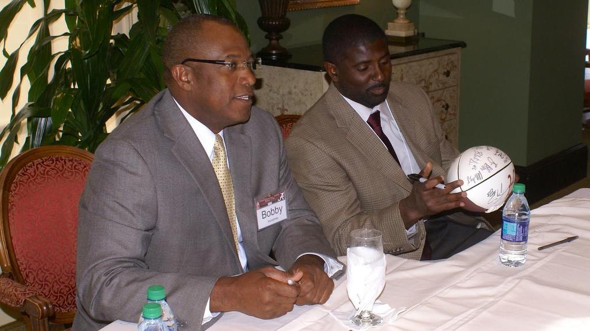 Former Alabama running back Bobby Humphrey, left, and current secondary coach Derrick Ansley sign autographs for fans at the Chattahoochee Valley Bama Club annual spring dinner Monday night at the Green Island Country Club in Columbus.