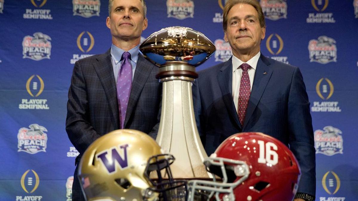 Alabama head coach Nick Saban, right, and Washington head coach Chris Petersen pose for a photo with the trophy during an NCAA college football press conference for the Peach Bowl, Friday, Dec. 30, 2016 in Atlanta. Washington plays Alabama on Saturday.