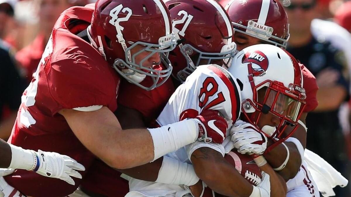 Western Kentucky wide receiver Kylen Towner, center, is tackled by Alabama linebacker Keith Holcombe, left, and Alabama defensive back Rogria Lewis during the first half of a game on Sept. 10.