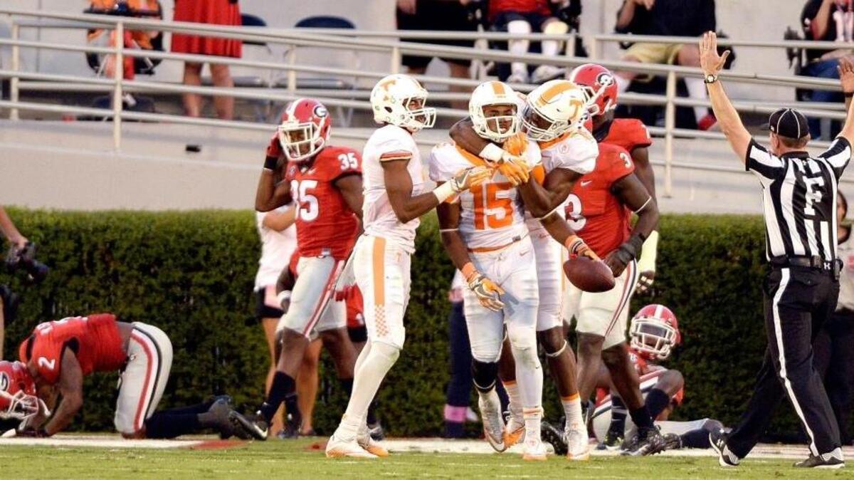Georgia players fall to the ground as Tennessee receiver Jauan Jennings (15) is congratulated by teammates after hauling in a desperation pass to win the game Saturday.