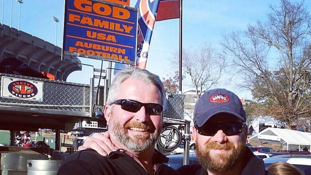 Auburn fanatic Ben Bone (right) poses alongside fellow fan Dan Ramsel with Bone’s grill setup positioned behind them. Bone is ready to bring his grill to Jordan-Hare Stadium early Saturday morning.