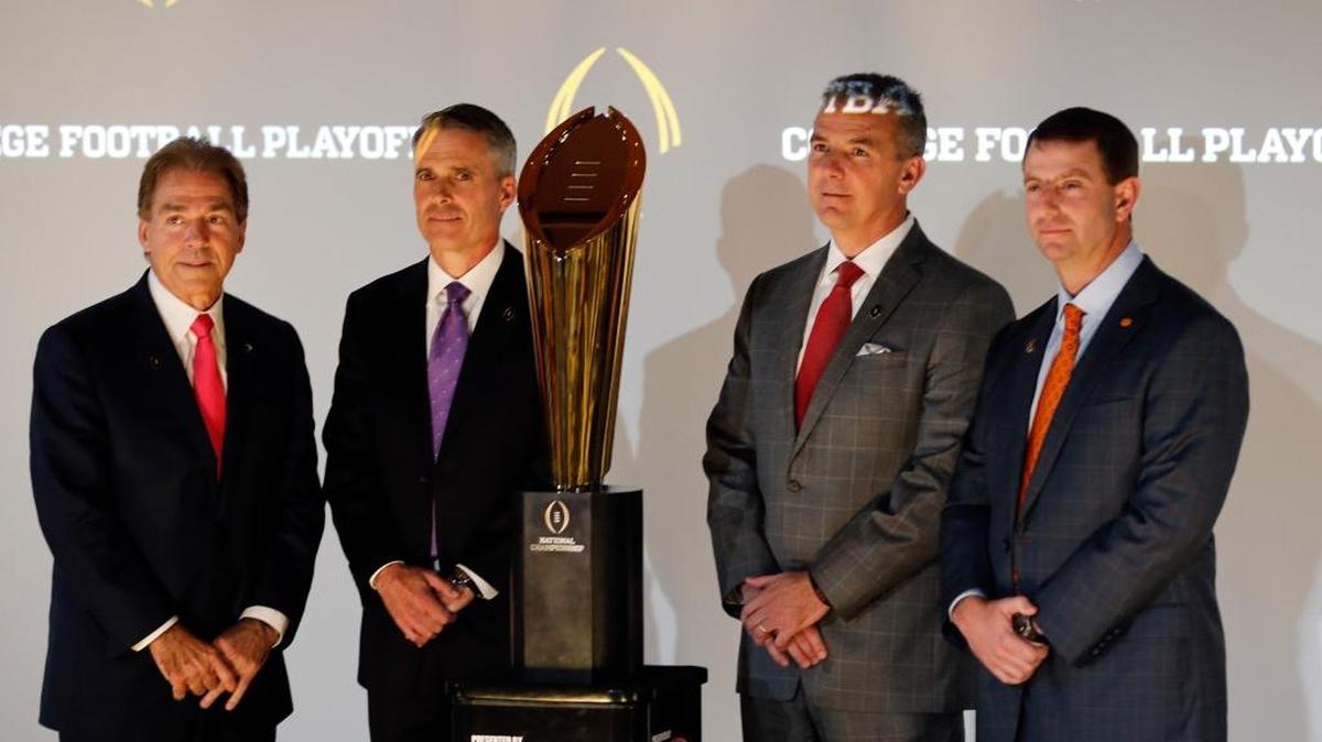 College football coaches from left to right; Nick Saban of Alabama, Chris Petersen of Washington, Ohio State's Urban Meyer and Dabo Sweeney of Clemson pose the college football championship trophy Thursday, Dec. 8, 2016, in Atlanta.
