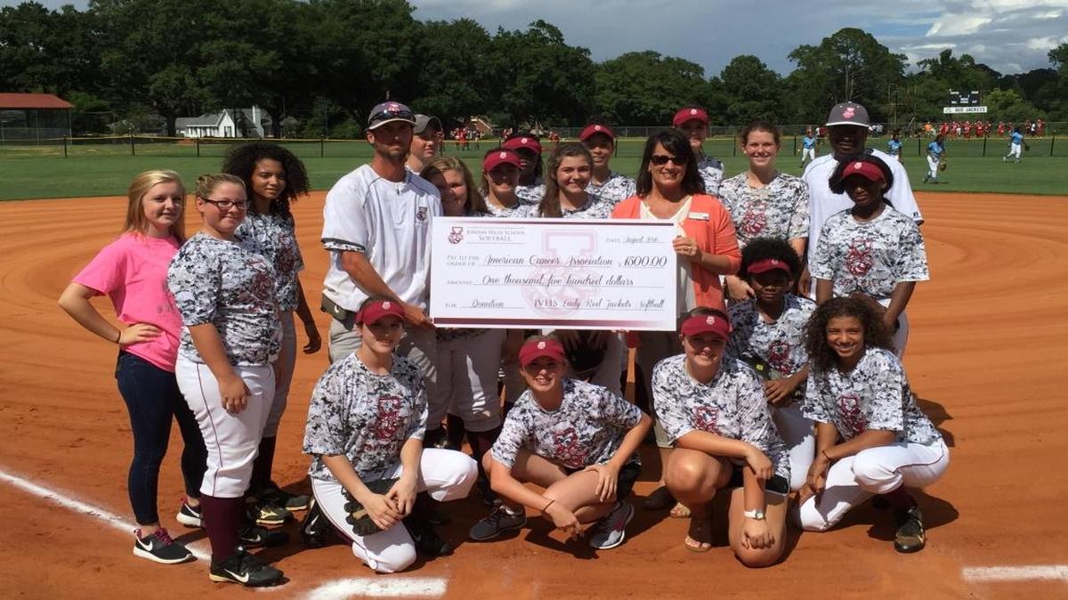 The Jordan softball team and coach John Dimitri presents an oversized check for $1,500 to Denise Dowdy of the local chapter of the American Cancer Society.