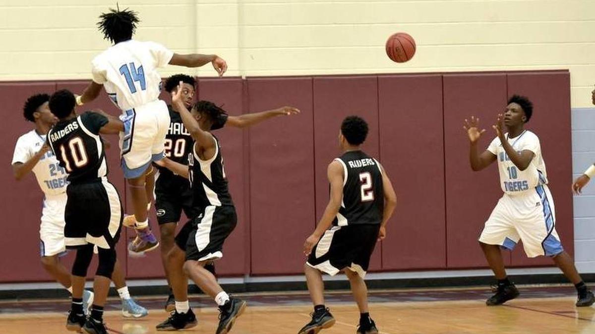 Carver's AJ Watts goes up to the basket against several Shaw defenders and passes the ball to Dexter Simmons for two points early in the first quarter of the game Friday night, December 15, 2017