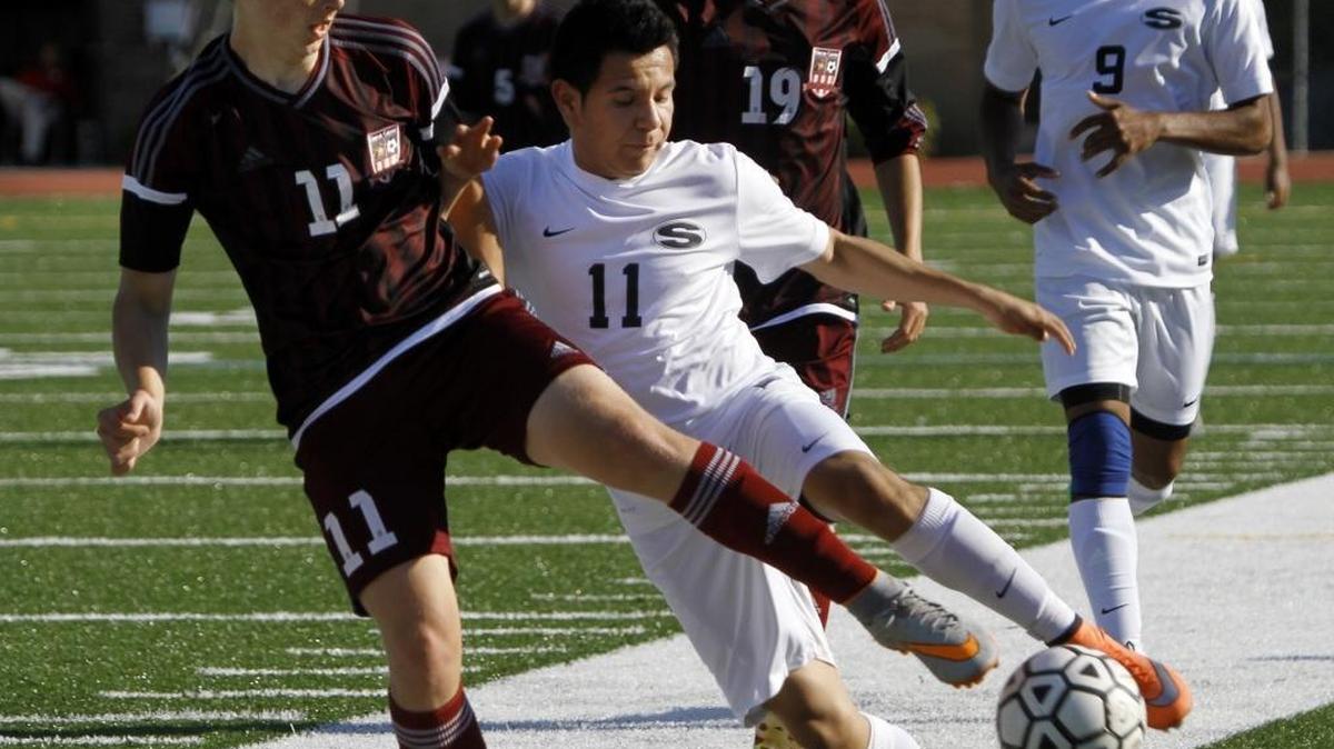 Shaw’s Christian De Anda battles for the ball against Union Grove’s Cade LeJune in Tuesday’s match at Kinnett Stadium.